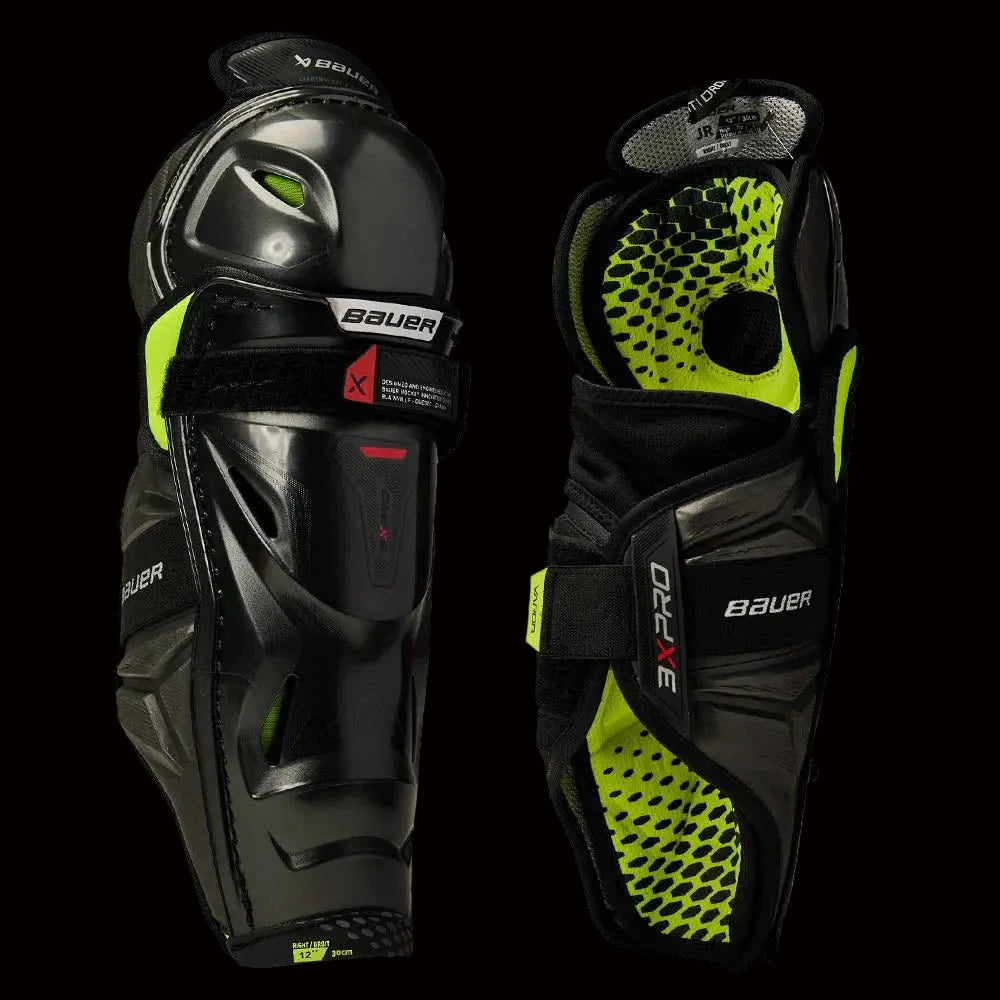 A pair of Bauer Vapor 3X Pro shin guards with black and neon green color scheme.