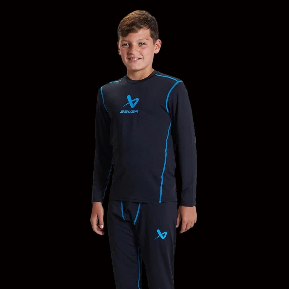 Boy wearing Bauer Basic Base Layer LS Top for comfort and mobility.