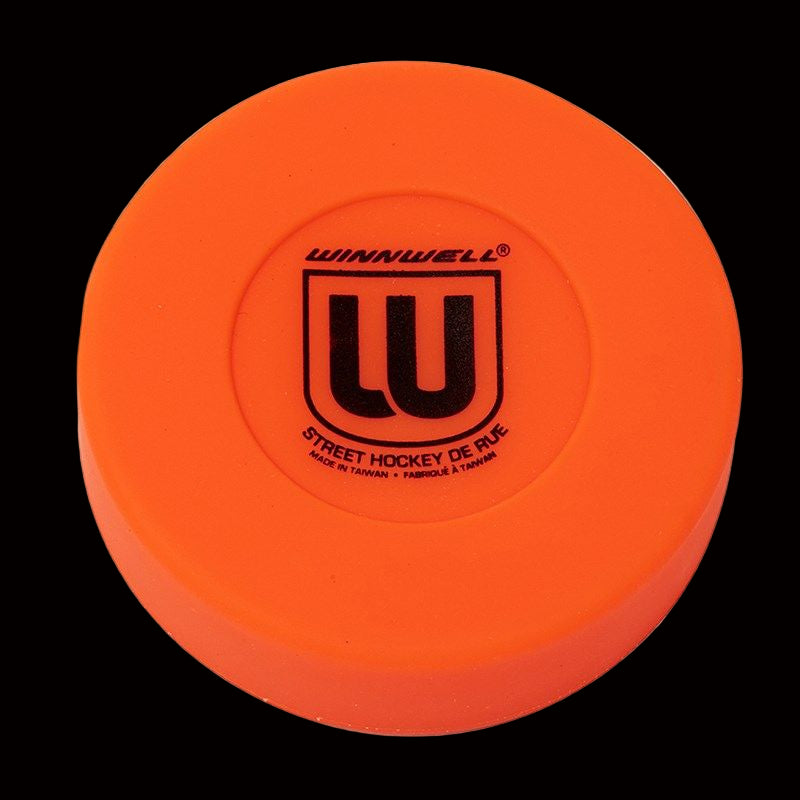 An orange Winnwell floor hockey puck with the brand's logo on it.