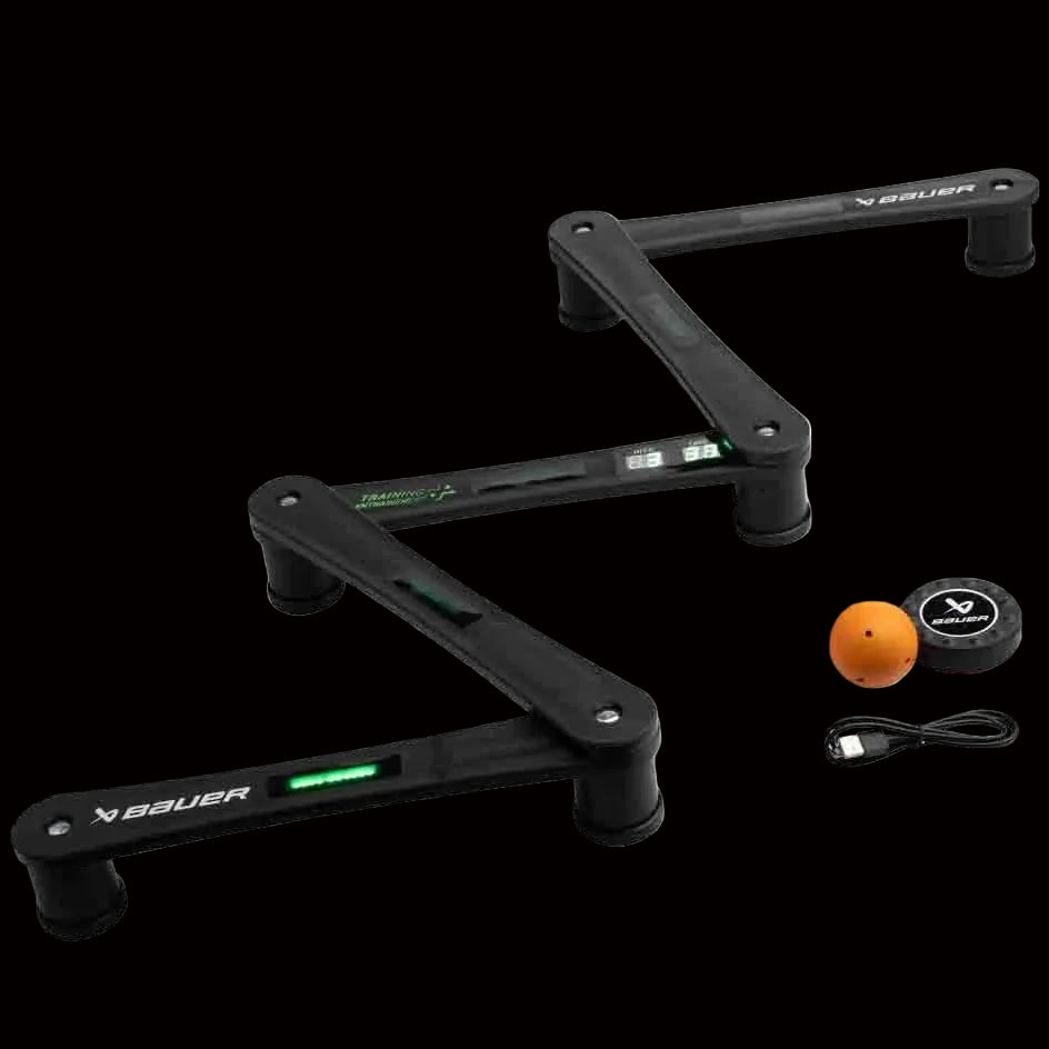 A Bauer Digital Reactor Stick Handling Trainer consisting of a black frame with adjustable arms, a digital puck, a ball, and a USB charging cable.