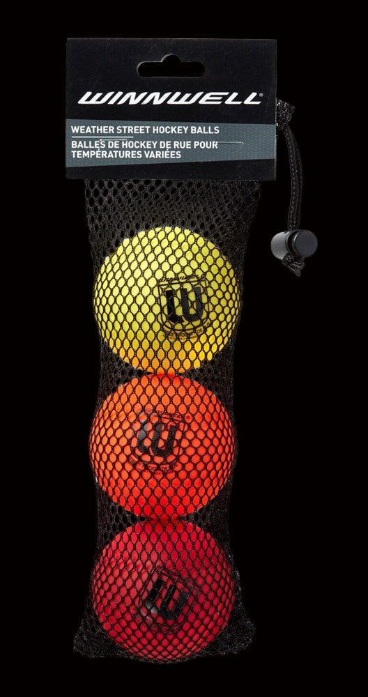 A three-pack of Winnwell multi.weather street hockey balls in red, yellow, and black colors, contained in a net bag.