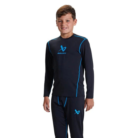 Boy wearing Bauer Basic Base Layer LS Top for comfort and mobility.