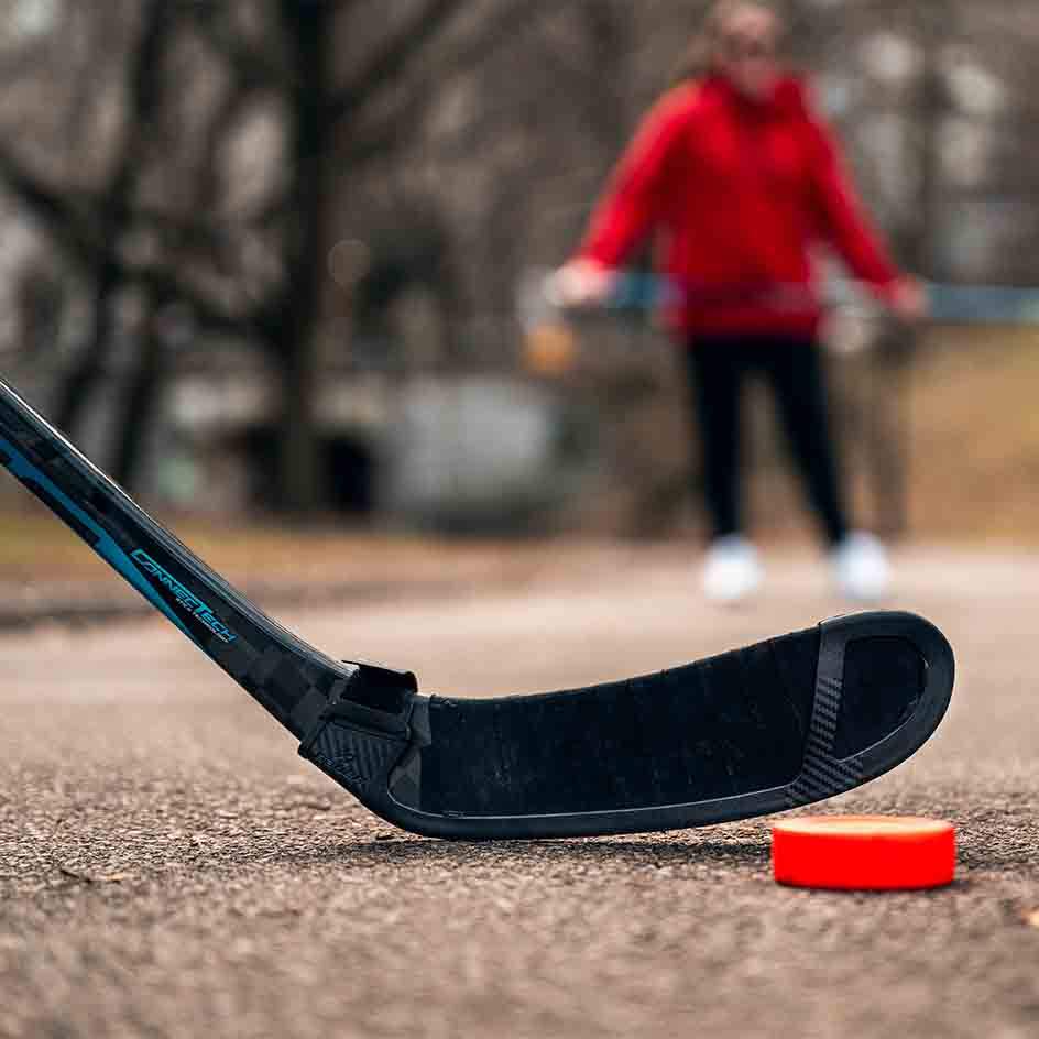 Bauer Blade Protector on a hockey stick with puck on outdoor surface