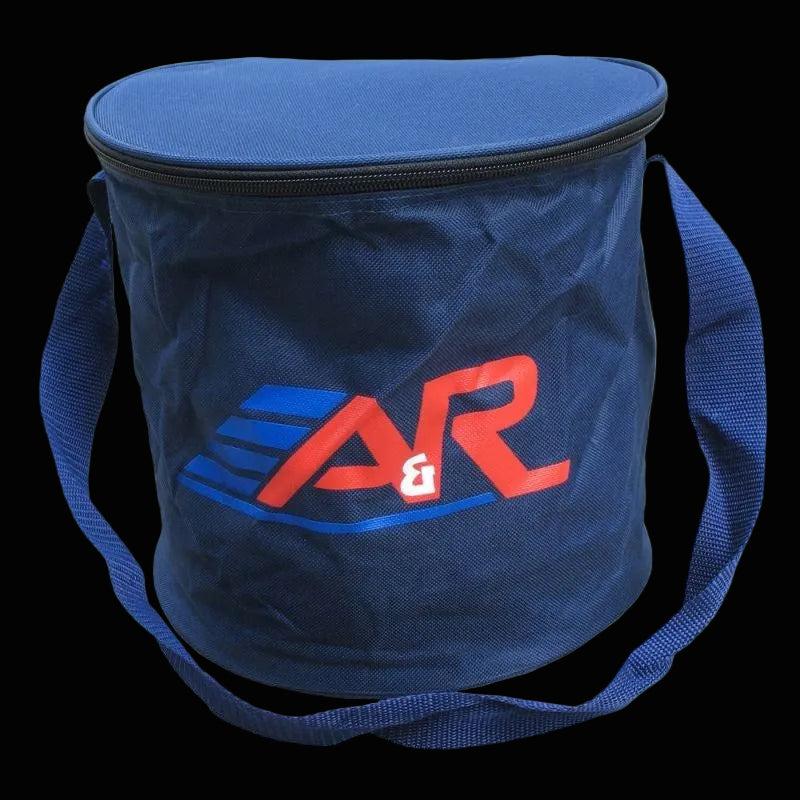 A blue canvas hockey puck bag with a wide mouth, zippered opening, and a reinforced shoulder strap. The bag has a red and white 'A&R' logo on the side.